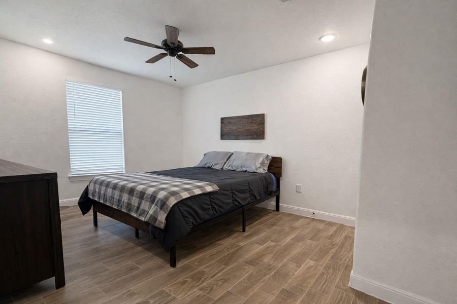 Bedroom with wood tiled floors, ceiling fan, and recessed lighting Bedroom with wood tiled floors, ceiling fan, and recessed lighting