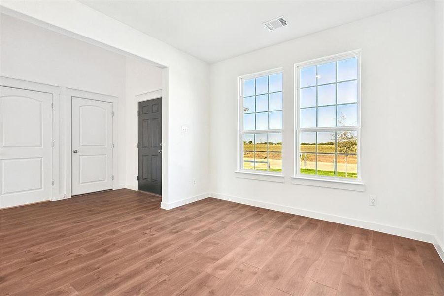 Unfurnished bedroom featuring dark wood-style floors and baseboards