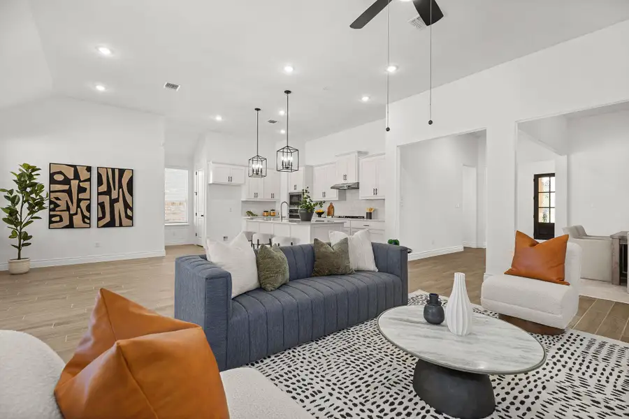 Living room featuring light wood finished floors, a chandelier, recessed lighting, and a ceiling fan