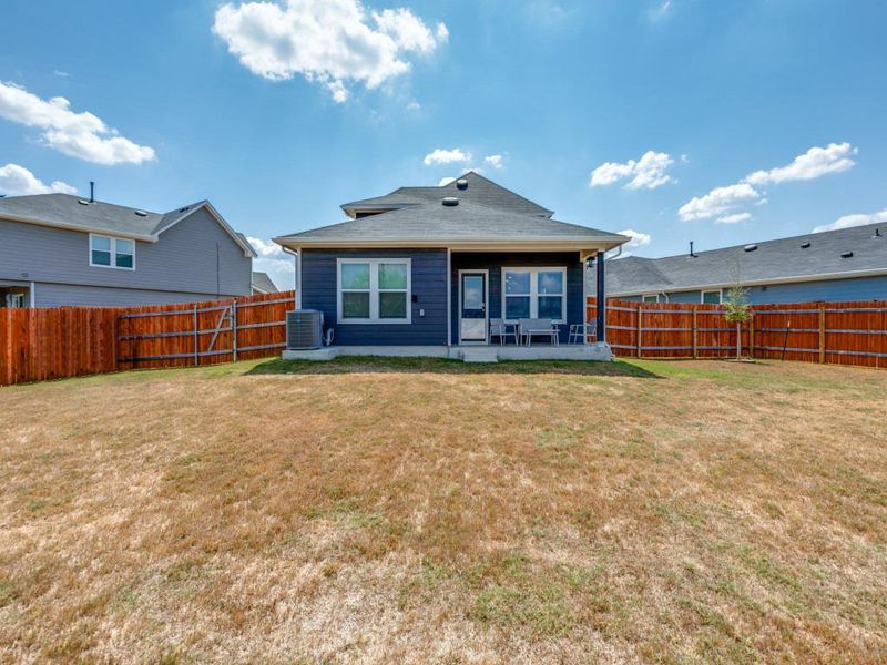 Rear view of property with a patio area, a fenced backyard, and roof with shingles