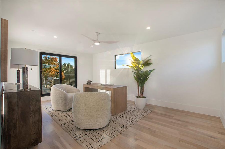 Living room with ceiling fan and light hardwood / wood-style floors