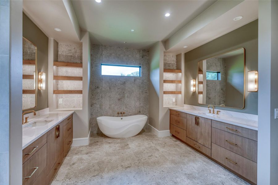 Bathroom with two vanities, a freestanding bath, baseboards, and recessed lighting