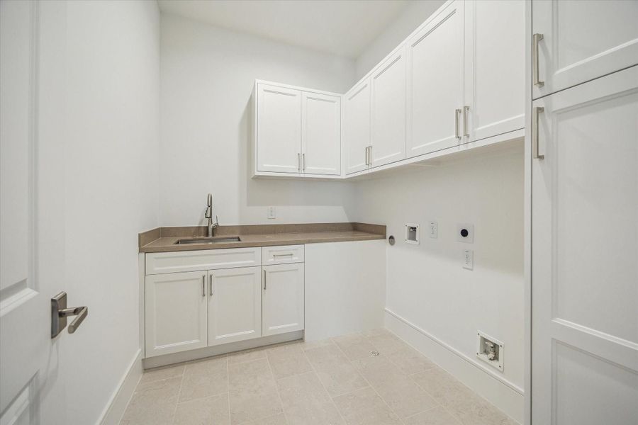 Second-floor utility room features Silestone Coral Clay Quartz countertops, sink and cabinet storage.