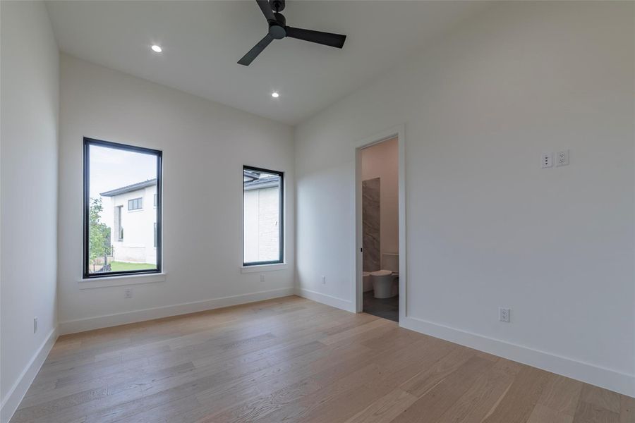 Unfurnished bedroom with light wood-type flooring, a ceiling fan, recessed lighting, and ensuite bathroom