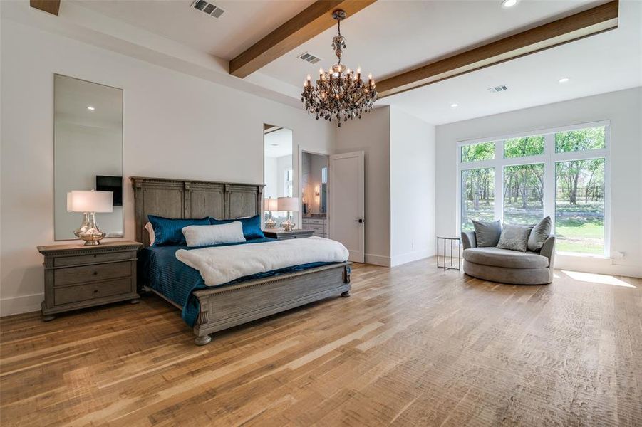 Bedroom featuring beam ceiling, a notable chandelier, and light hardwood / wood-style flooring