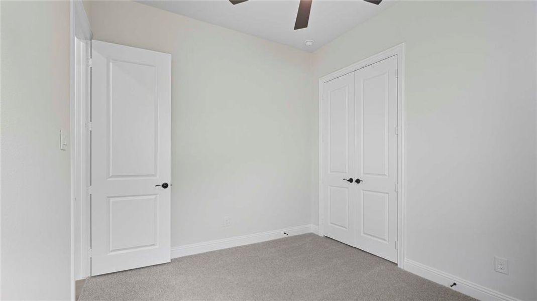 Neutral-toned room with light gray carpeting and white baseboards