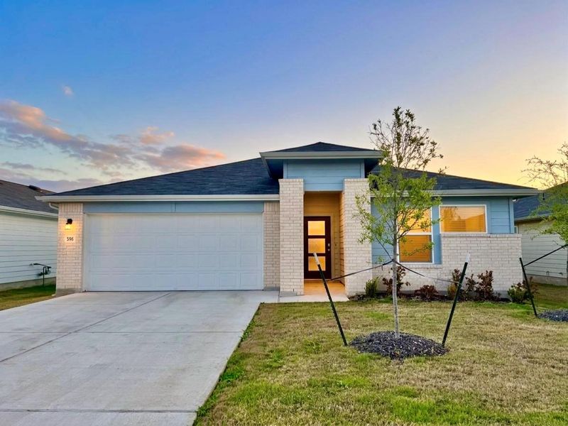 View of front of property with brick siding, an attached garage, driveway, and a front yard View of front of property with brick siding, an attached garage, driveway, and a front yard