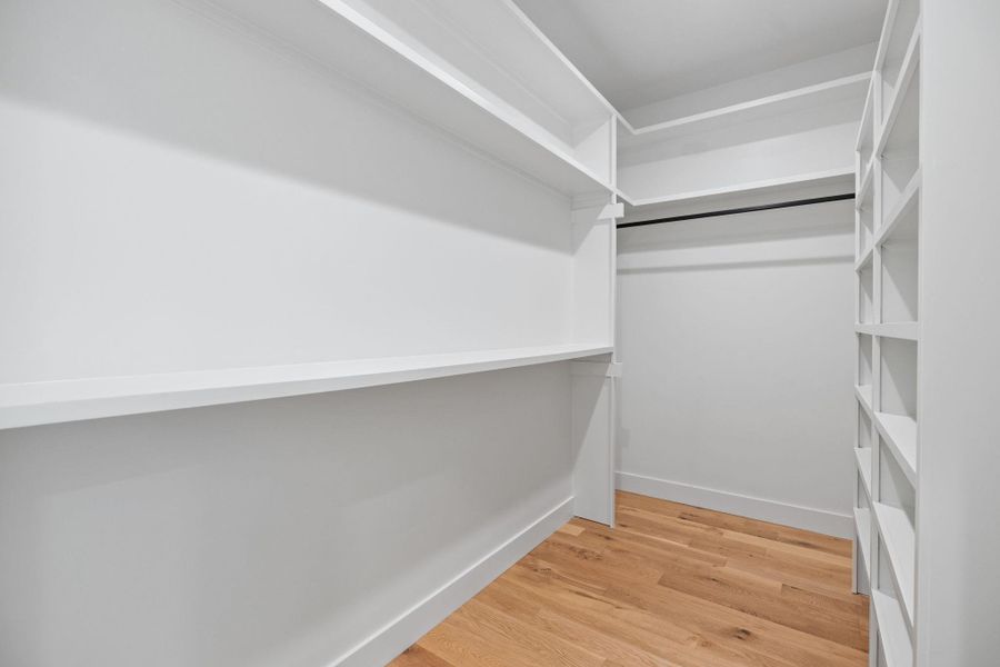 Spacious closet featuring light wood finished floors Spacious closet featuring light wood finished floors