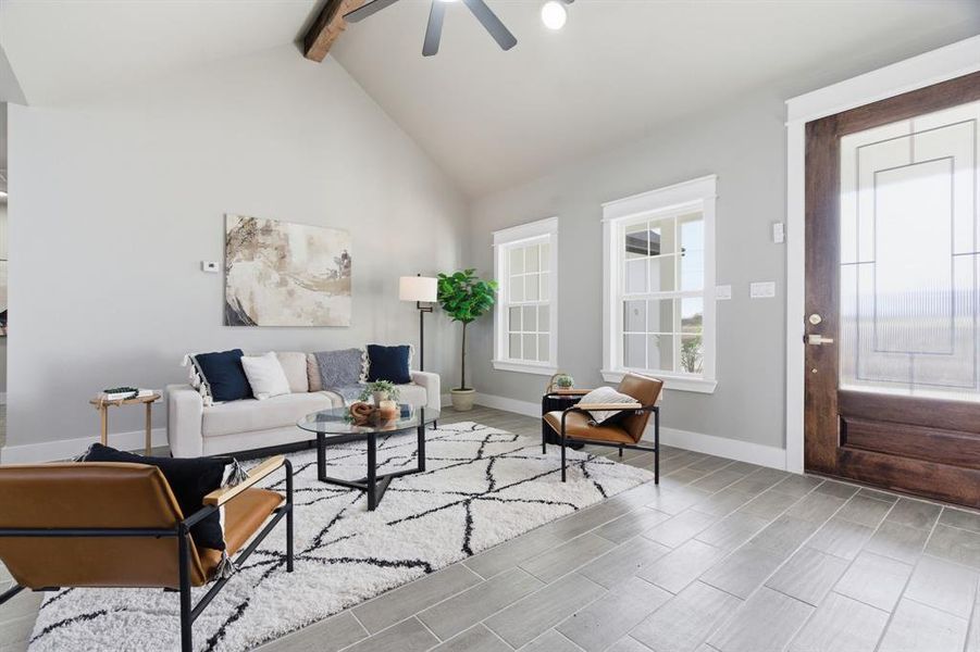 Living area with beam ceiling, high vaulted ceiling, ceiling fan, and wood finish floors