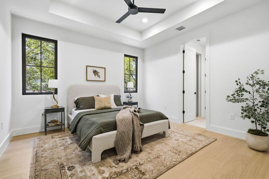 Crisp white walls contrast with dark-framed windows and warm wood floors in this serene retreat.