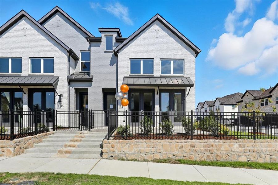 View of front of house featuring brick siding, a standing seam roof, and a metal roof View of front of house featuring brick siding, a standing seam roof, and a metal roof