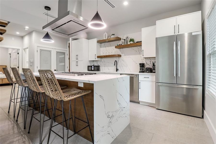 A well-appointed kitchen features a spacious island with bar seating and integrated appliances.