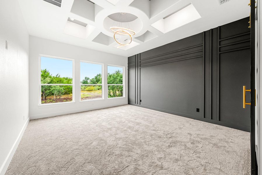 A well-lit room with recessed lighting and a unique ceiling design provides a welcoming atmosphere.