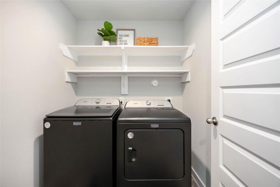 Walk-in laundry room on first floor with ample shelving. Walk-in laundry room on first floor with ample shelving.