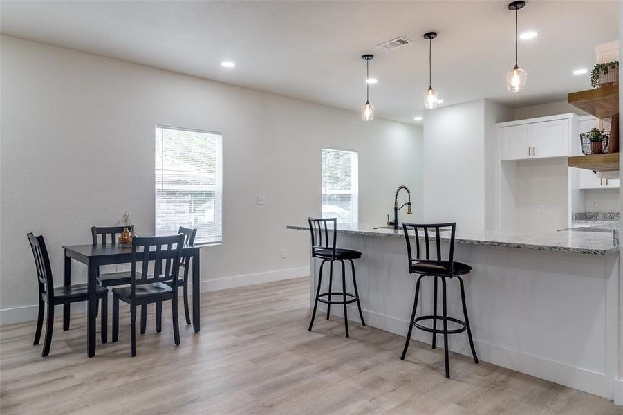 Kitchen with white cabinetry, a wealth of natural light, and light wood-type flooring