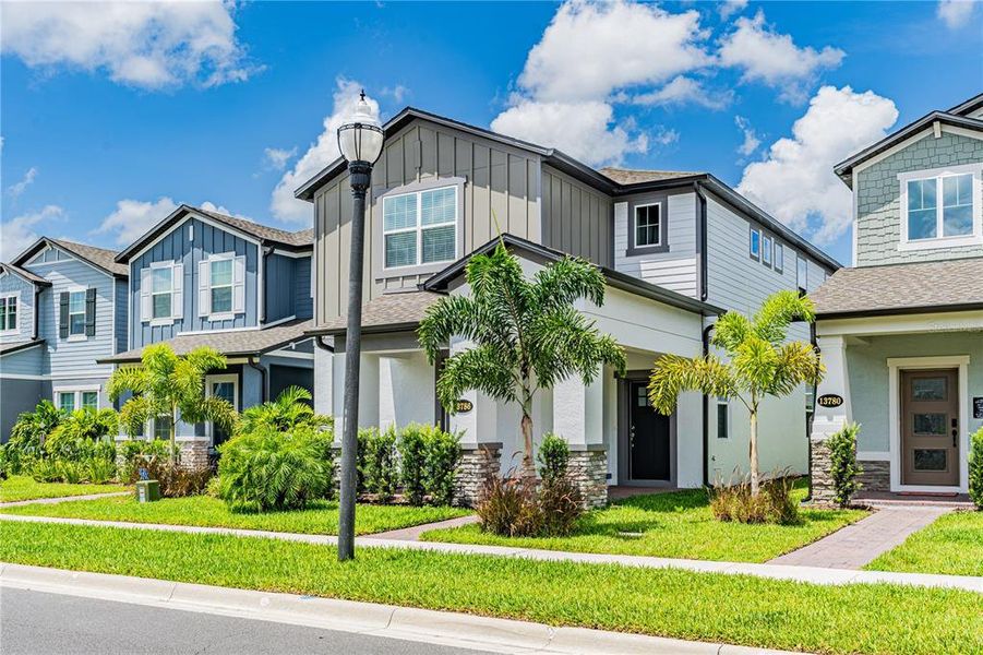 Front exterior of a new home in Encore at Ovation, Winter Garden, FL, highlighting curb appeal (Image 25).
