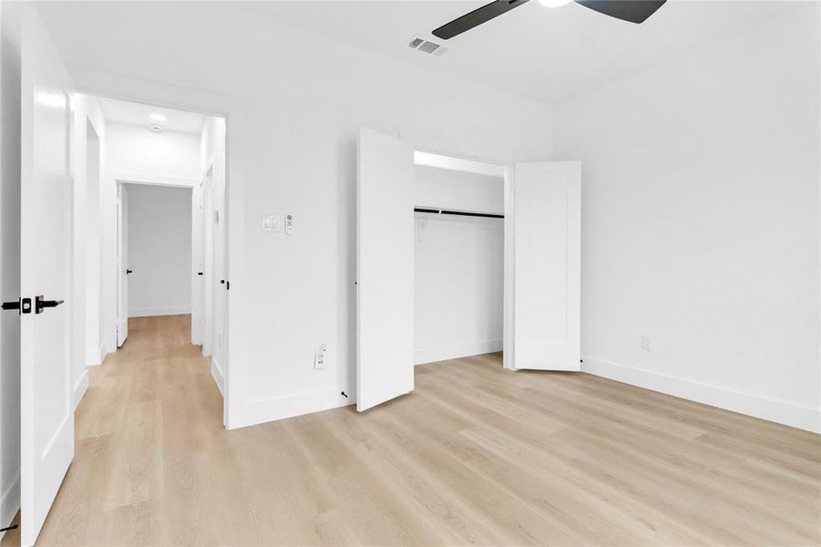 Unfurnished bedroom featuring a closet, light wood-type flooring, and a ceiling fan