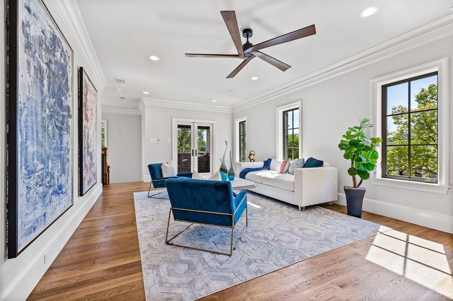 Living room featuring a ceiling fan, wood finished floors, baseboards, ornamental molding, and recessed lighting Living room featuring a ceiling fan, wood finished floors, baseboards, ornamental molding, and recessed lighting