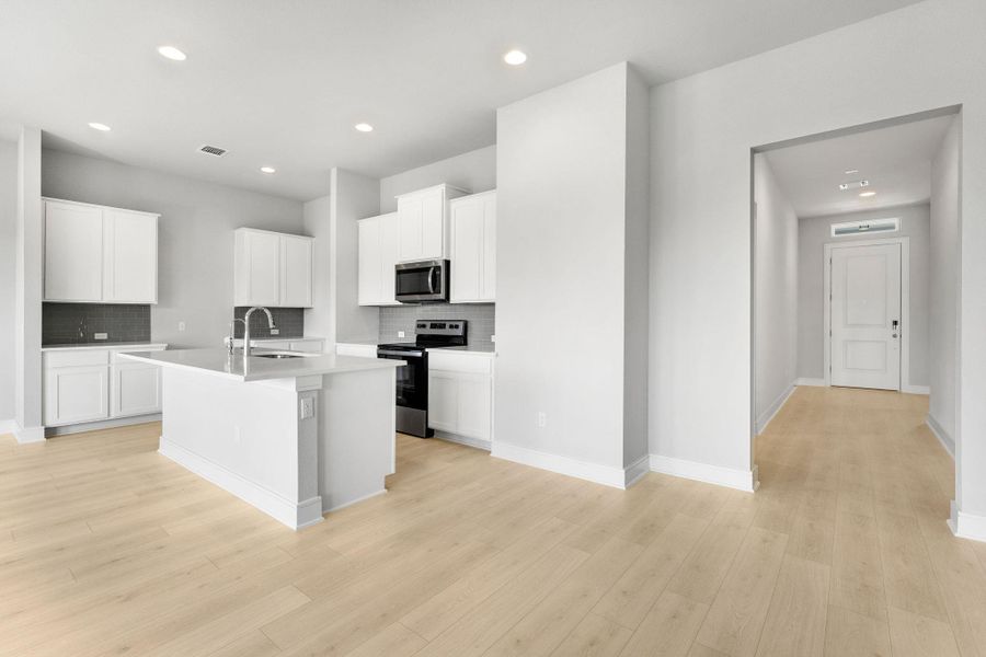 A well-lit kitchen with sleek appliances and light hardwood floors. A well-lit kitchen with sleek appliances and light hardwood floors.