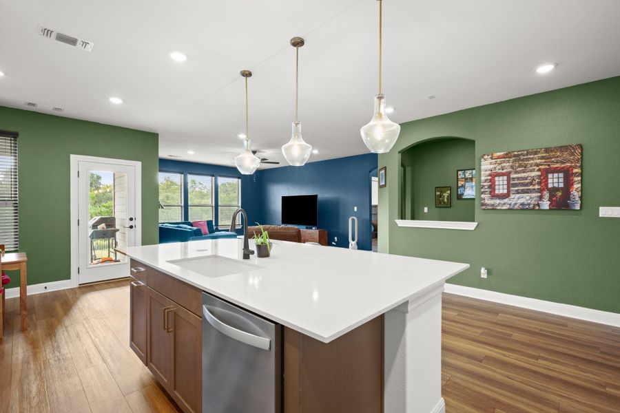 Kitchen with stainless steel dishwasher, light wood-style flooring, recessed lighting, an island with sink, and open floor plan Kitchen with stainless steel dishwasher, light wood-style flooring, recessed lighting, an island with sink, and open floor plan