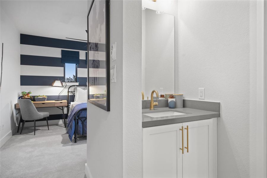 Bathroom featuring vanity, light carpet, and a textured wall