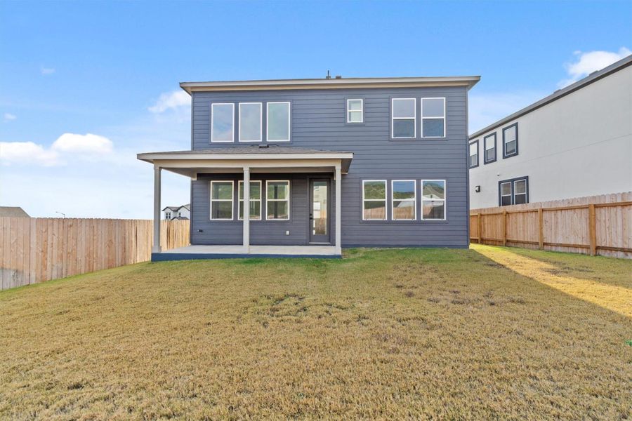 Rear view of house featuring a patio area and a yard