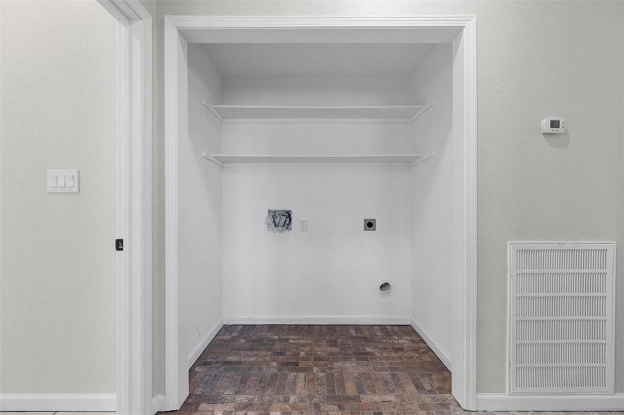 Laundry area with brick patterned flooring, hookup for an electric dryer, and hookup for a washing machine Laundry area with brick patterned flooring, hookup for an electric dryer, and hookup for a washing machine