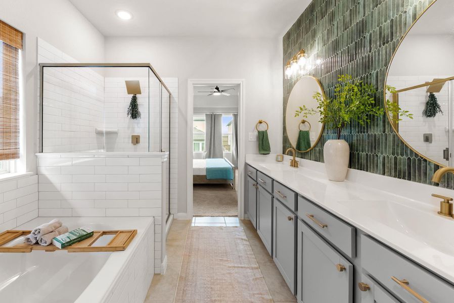 Ensuite bathroom with double vanity, a stall shower, light tile patterned flooring, a bath, and tile walls