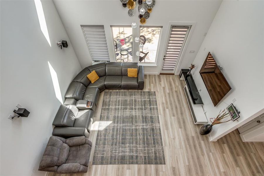 Expansive living room with soaring ceilings and an abundance of windows adorned with luxury motorized blinds. Gorgeous, easy-to-clean light wood–style luxury vinyl plank flooring flows seamlessly to the outdoor patio—perfect for indoor-outdoor living and entertaining! Expansive living room with soaring ceilings and an abundance of windows adorned with luxury motorized blinds. Gorgeous, easy-to-clean light wood–style luxury vinyl plank flooring flows seamlessly to the outdoor patio—perfect for indoor-outdoor living and entertaining!