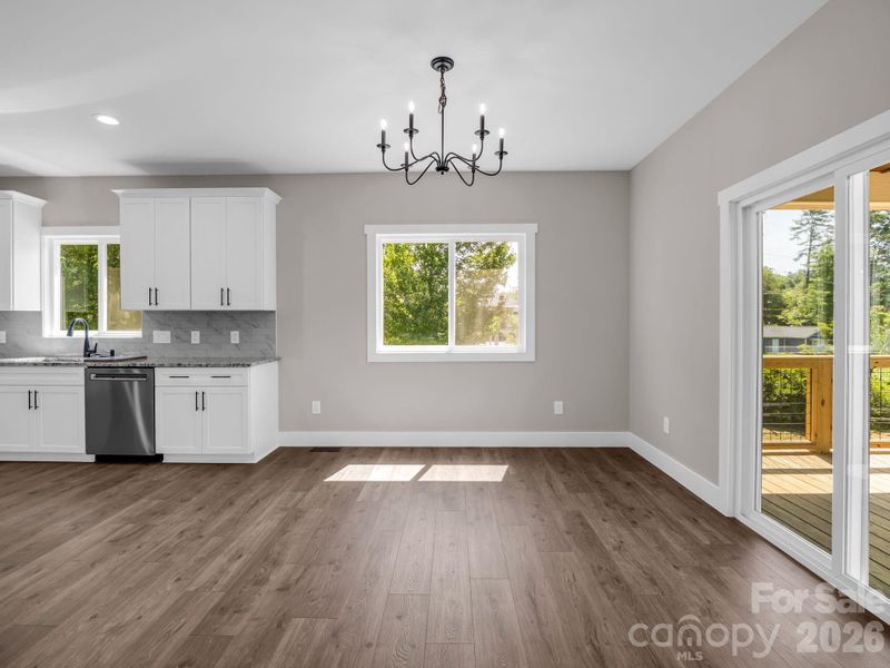 View from living room to dining room, kitchen to the left and sliders to covered rear porch View from living room to dining room, kitchen to the left and sliders to covered rear porch