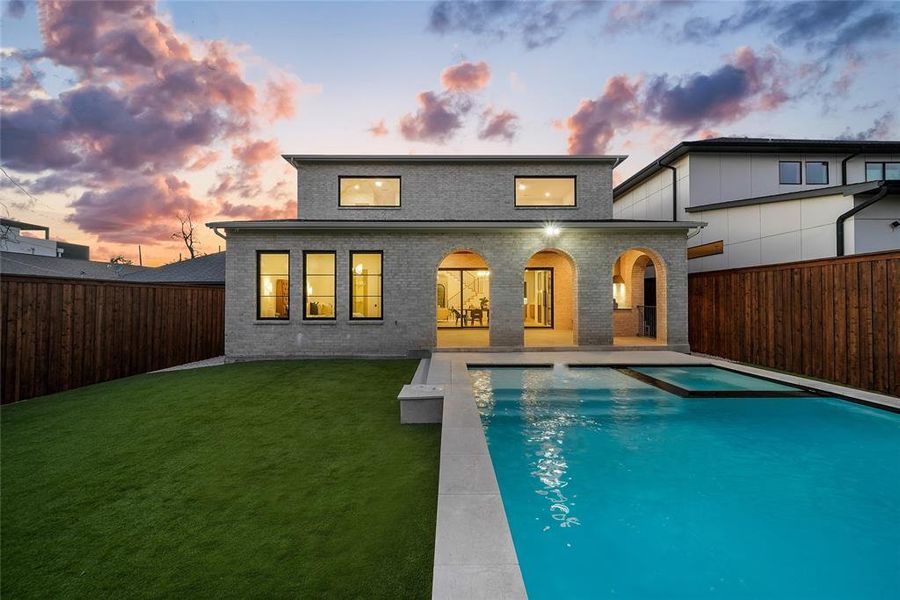 Back of property with a patio, brick siding, a fenced backyard, and a pool with connected hot tub Back of property with a patio, brick siding, a fenced backyard, and a pool with connected hot tub