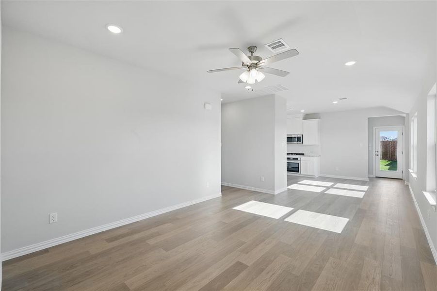 Unfurnished living room featuring a ceiling fan, light wood finished floors, and recessed lighting Unfurnished living room featuring a ceiling fan, light wood finished floors, and recessed lighting