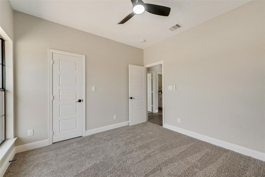 Unfurnished bedroom featuring ceiling fan and carpet flooring