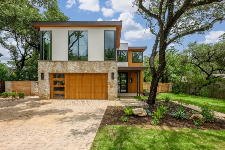 Modern facade with mixed materials welcomes you to this verdant property. Modern facade with mixed materials welcomes you to this verdant property.