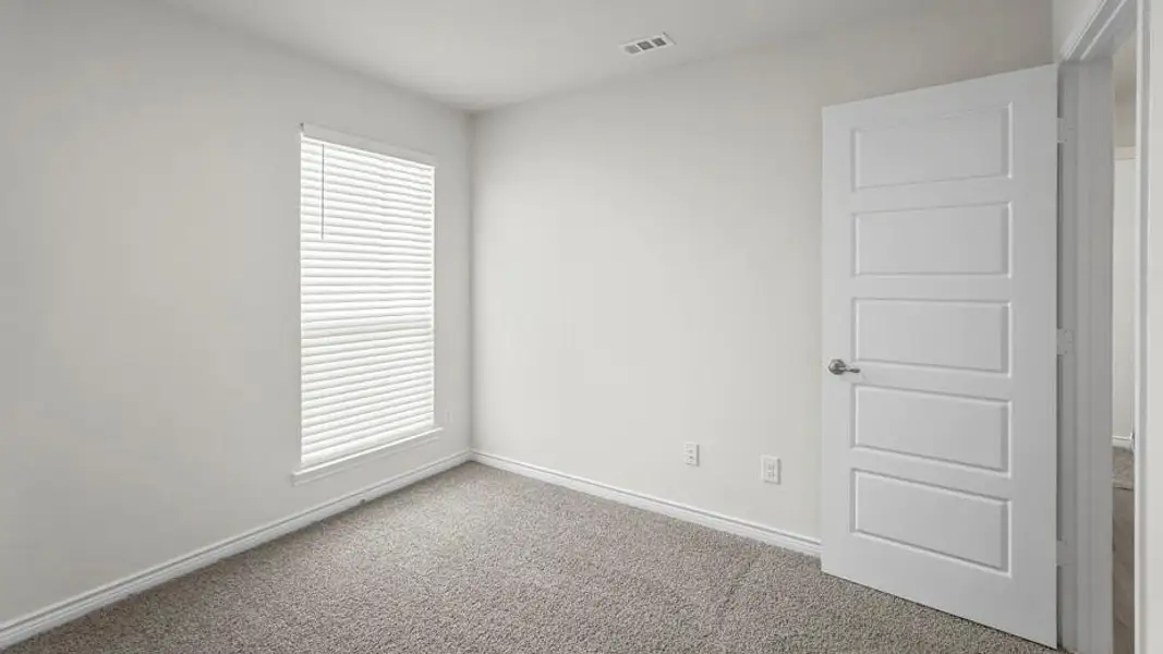 This room features light gray walls, gray carpeting, and a window with white blinds
