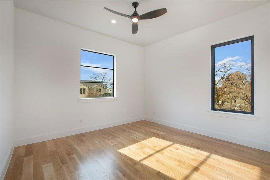 Unfurnished room with ceiling fan and light wood-type flooring