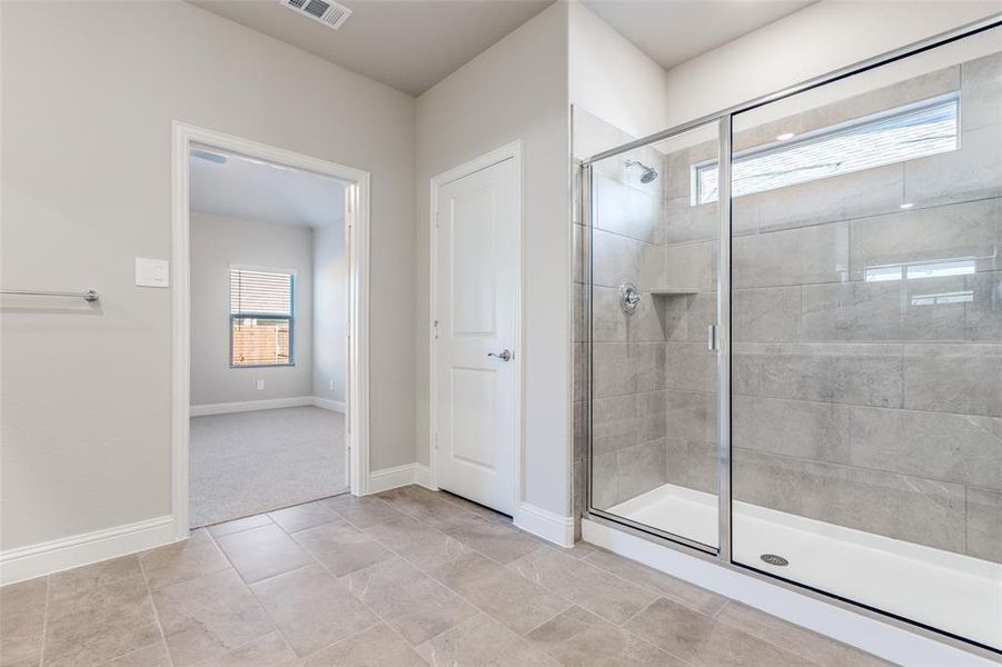 Bathroom with a shower stall and baseboards Bathroom with a shower stall and baseboards