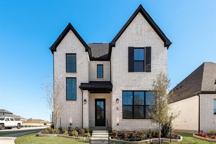 View of front of home with brick siding, roof with shingles, and a front yard View of front of home with brick siding, roof with shingles, and a front yard