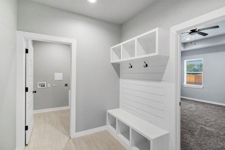 Mudroom with light carpet and ceiling fan