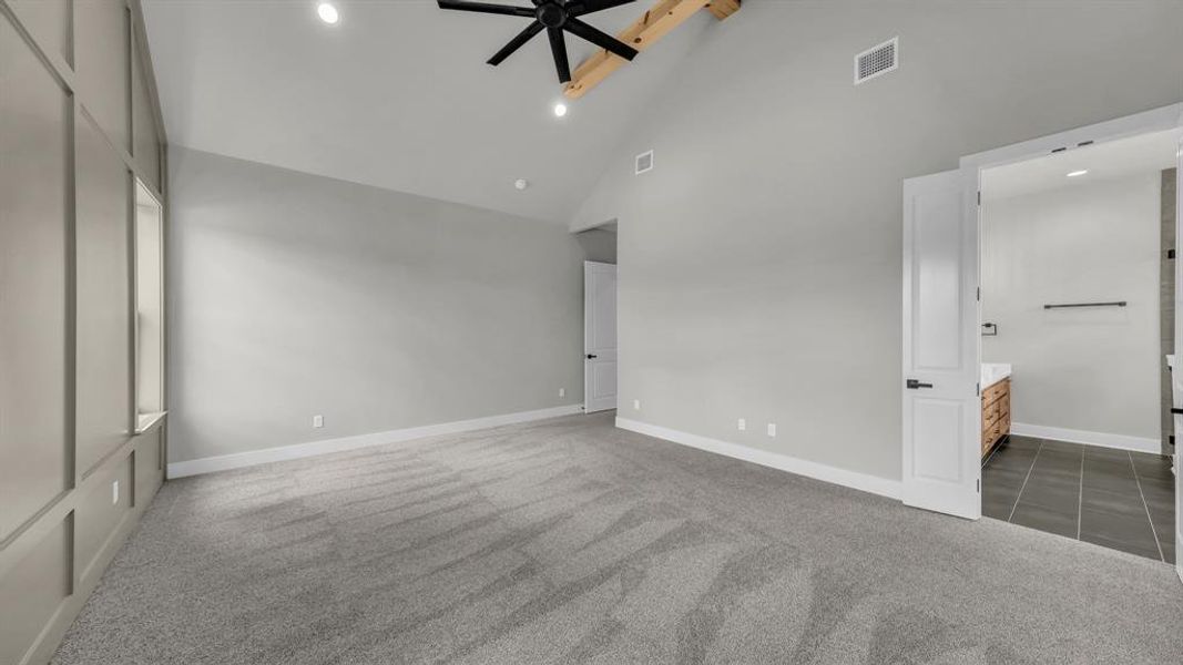 Spacious room with vaulted ceilings and exposed wood beam accents