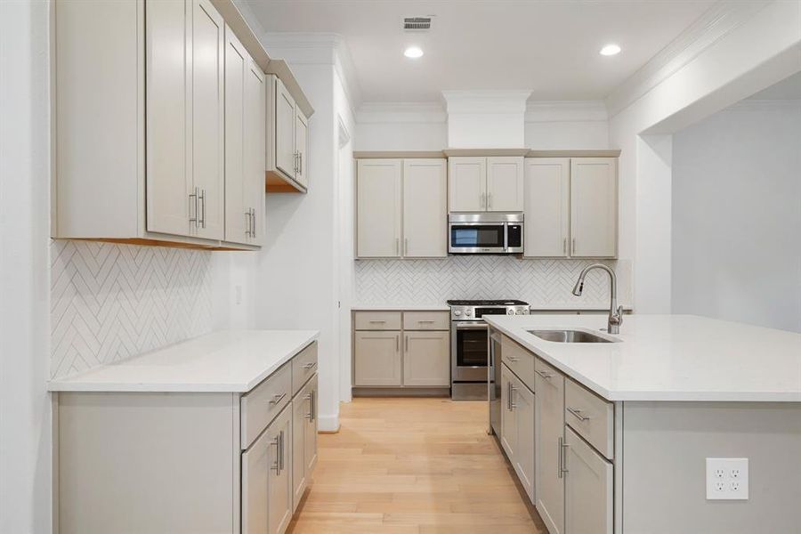 Fall in-love with this stunning kitchen! The space features custom cabinets, beautiful quartz countertops, and stainless-steel appliances! (Sample photos of a completed Lisbon floor plan. The image may feature alternative selections and/or upgrades.)