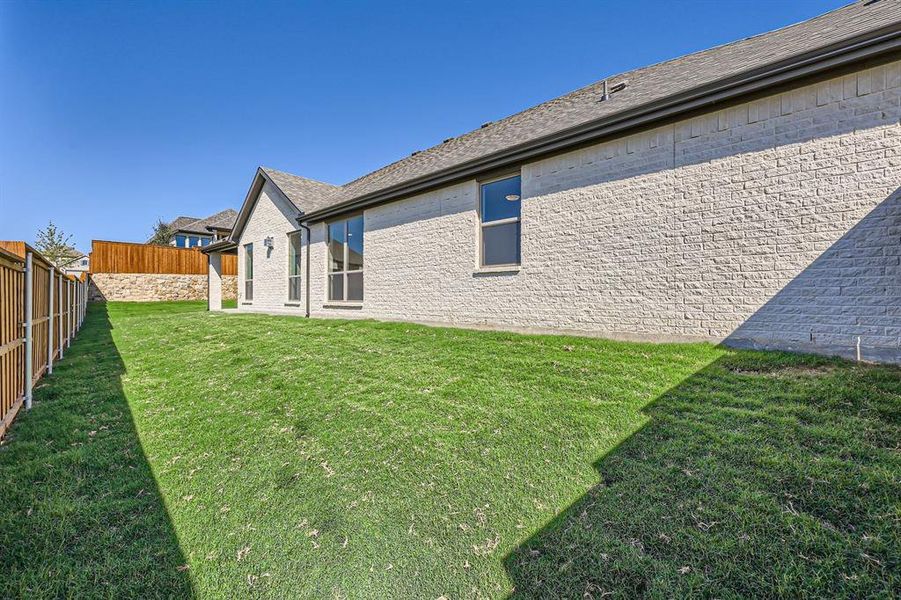 Rear view of property with a yard