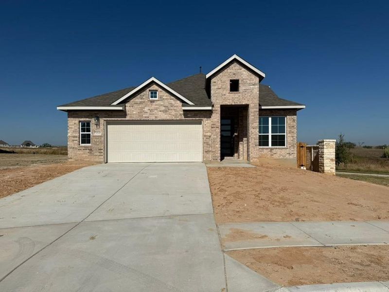 View of front of house with brick siding, driveway, an attached garage, and a shingled roof View of front of house with brick siding, driveway, an attached garage, and a shingled roof