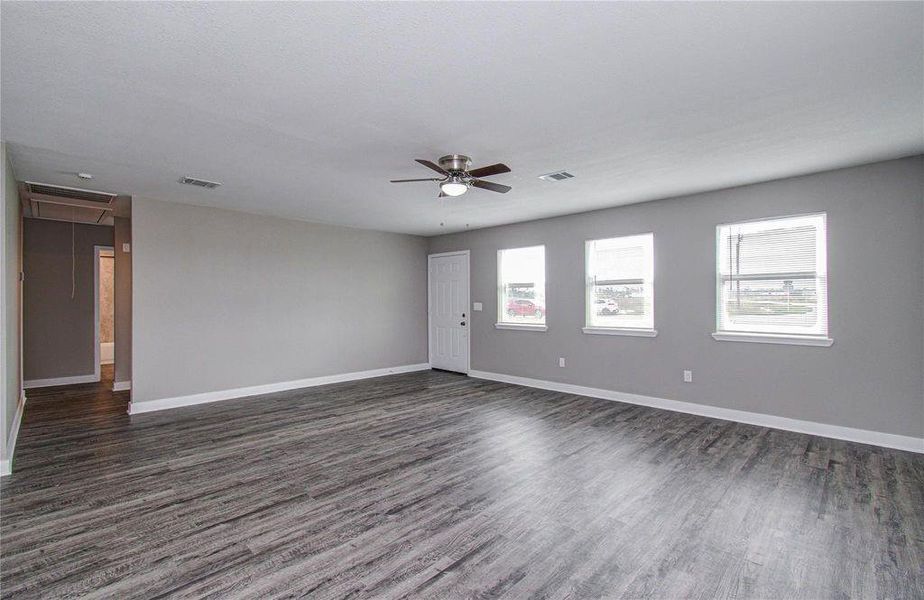 Generously sized living space with durable wood-look flooring and abundant natural light.