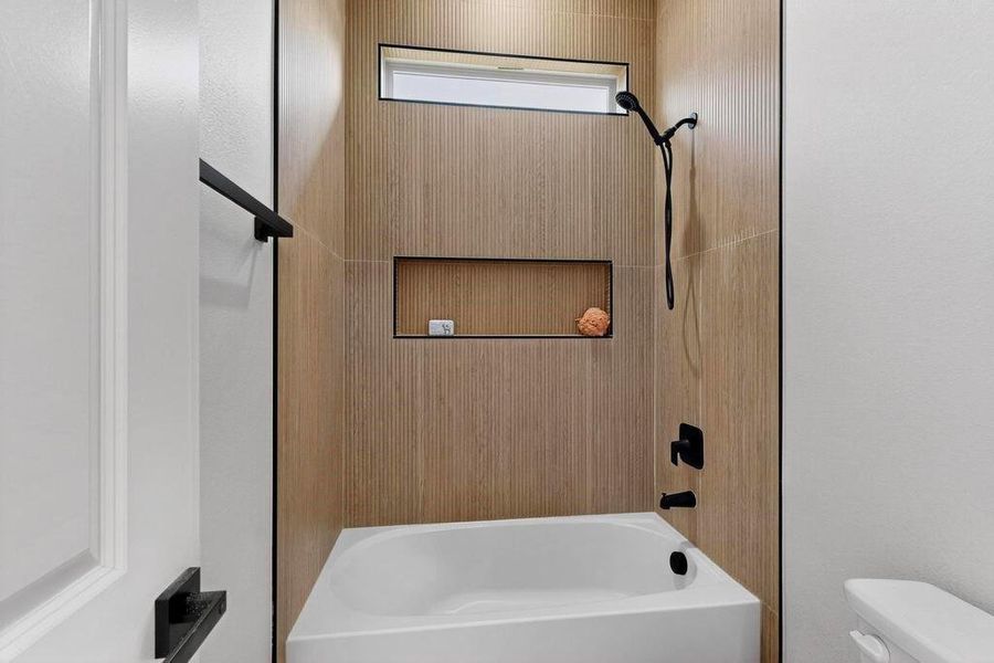 Full bath featuring toilet and washtub / shower combination