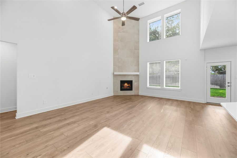 The family room includes LVP flooring, high ceiling and beautiful corner fireplace.