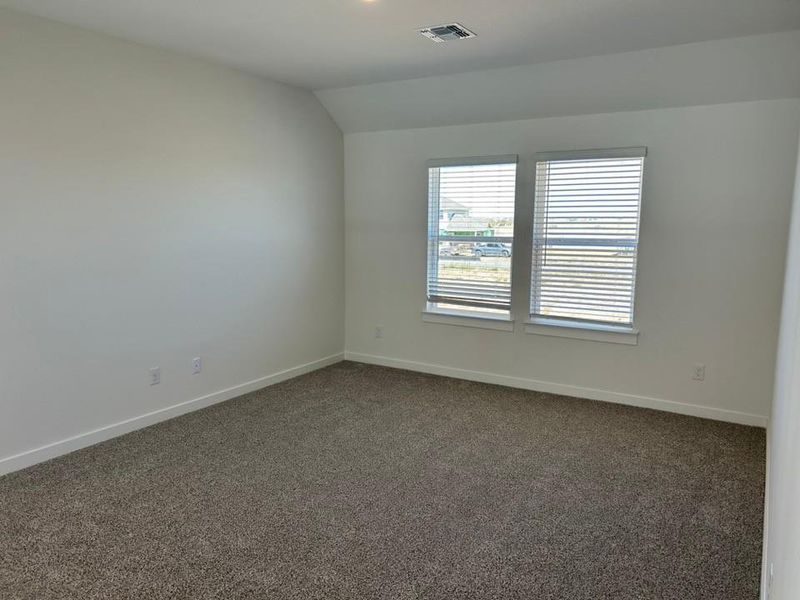 Spare room with dark colored carpet and vaulted ceiling Spare room with dark colored carpet and vaulted ceiling