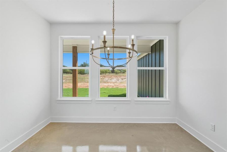 Unfurnished dining area with concrete flooring and a chandelier