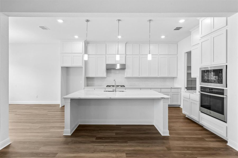 A well-appointed kitchen showcasing a spacious island, built-in appliances, and ample cabinet storage.