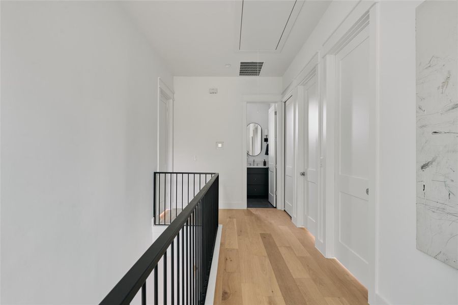 Hall with attic access and light wood finished floors Hall with attic access and light wood finished floors